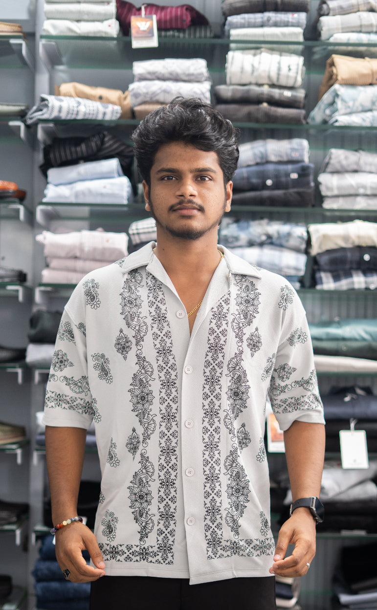 Man wearing a white patterned shirt in a clothing store